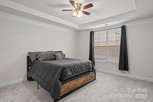 bedroom with multiple windows, a tray ceiling, and ceiling fan