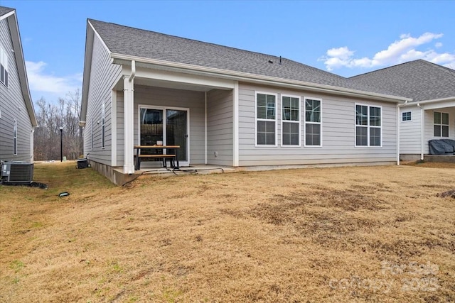 rear view of property featuring cooling unit and a lawn