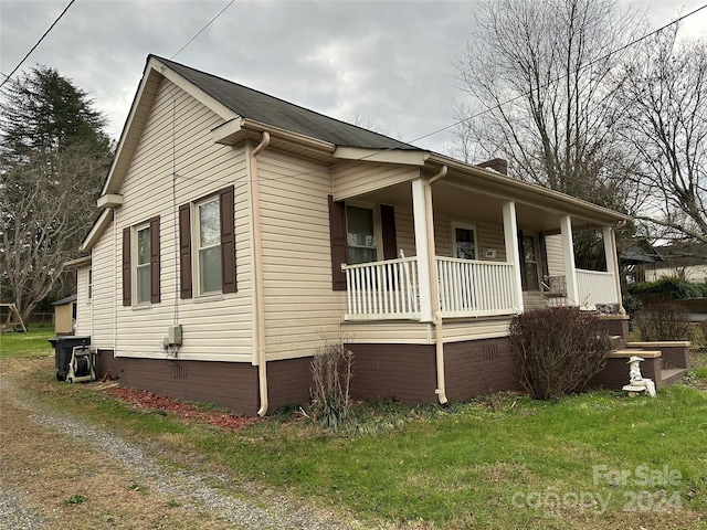 view of side of property with a lawn and a porch