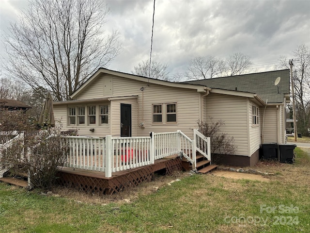 back of property featuring a yard and a deck