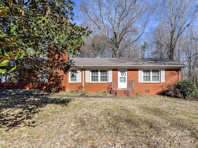 view of front of property featuring brick siding, crawl space, and a front yard