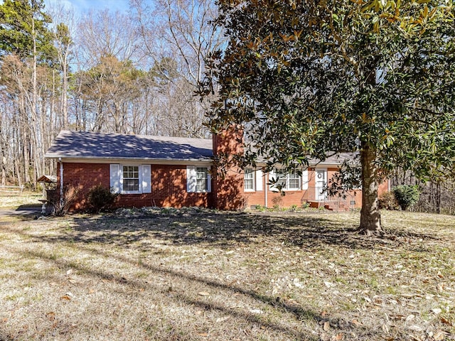 view of front of house with brick siding and a front lawn