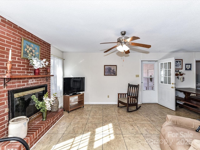 living area featuring a brick fireplace, baseboards, a textured ceiling, and tile patterned floors