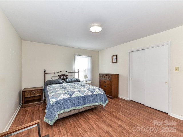 bedroom with a closet, baseboards, and wood finished floors