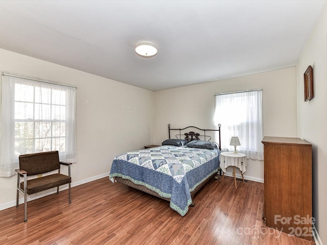 bedroom featuring wood finished floors and baseboards