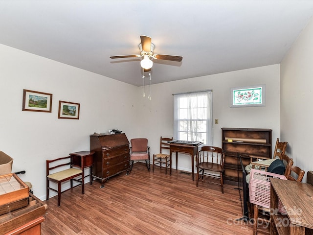 living area featuring ceiling fan, light wood-type flooring, and baseboards