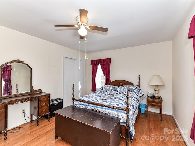 bedroom with ceiling fan, a closet, wood finished floors, and baseboards