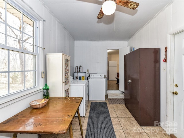 interior space featuring laundry area, a ceiling fan, washing machine and clothes dryer, crown molding, and light tile patterned flooring