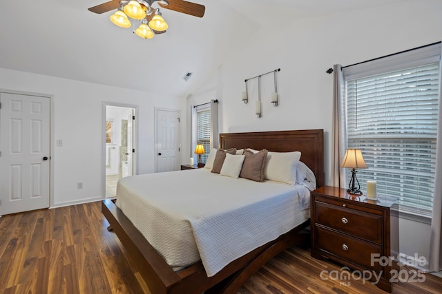 bedroom featuring vaulted ceiling, dark hardwood / wood-style floors, ensuite bath, and ceiling fan