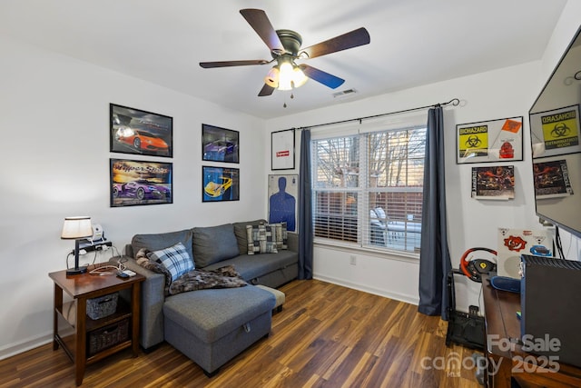 living area with ceiling fan and dark wood-type flooring