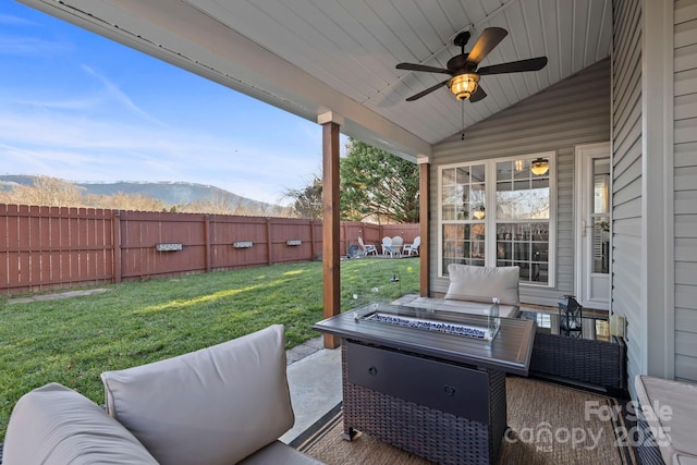 view of patio / terrace with a mountain view, a fire pit, and ceiling fan