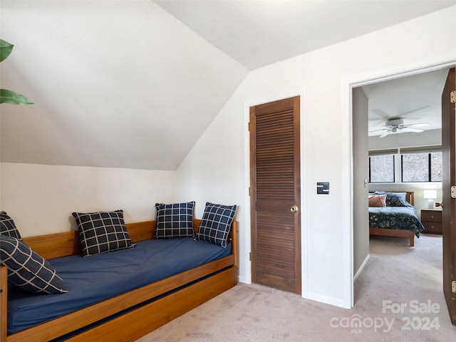 carpeted bedroom featuring a closet, lofted ceiling, and ceiling fan