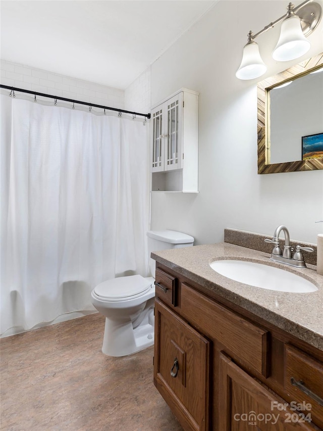 bathroom with hardwood / wood-style flooring, vanity, and toilet