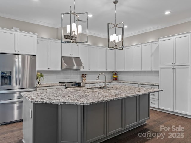 kitchen featuring white cabinets, appliances with stainless steel finishes, sink, and an island with sink