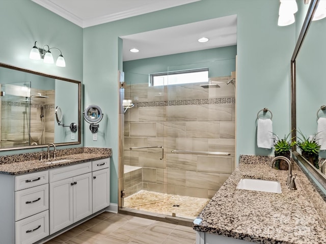 bathroom with vanity, a shower with door, and crown molding