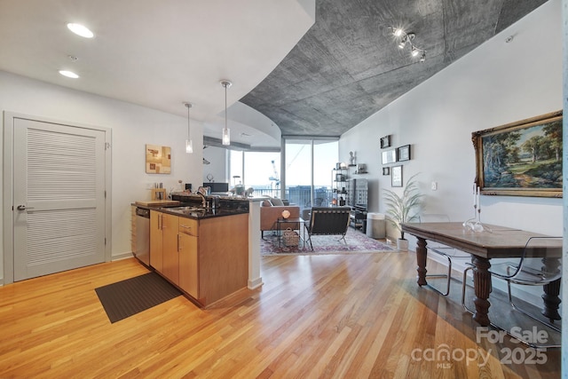 kitchen with dishwasher, sink, hanging light fixtures, light hardwood / wood-style flooring, and kitchen peninsula