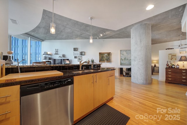 kitchen featuring light brown cabinetry, light wood-type flooring, sink, dishwasher, and hanging light fixtures