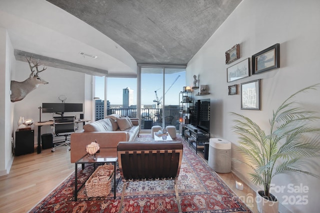 living room featuring light hardwood / wood-style flooring and a wall of windows