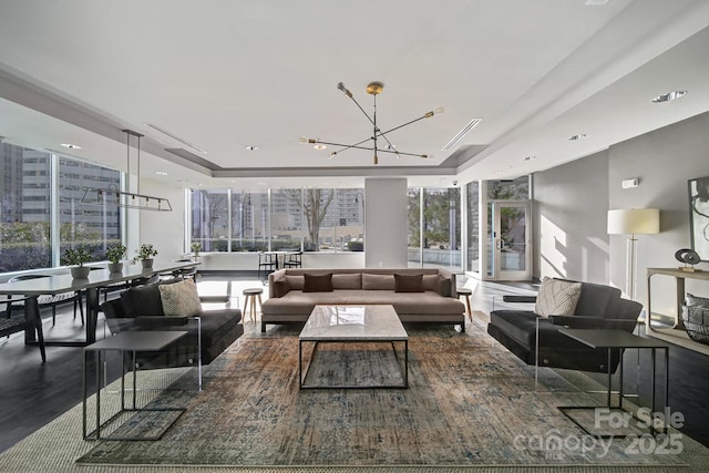 living room featuring a raised ceiling and a chandelier