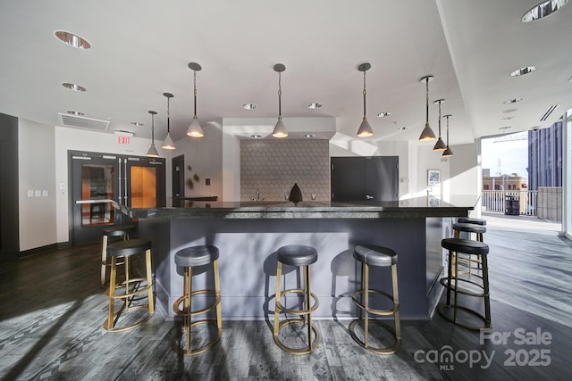 kitchen with refrigerator, decorative light fixtures, and a breakfast bar area