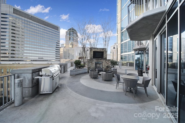 view of patio with a grill and an outdoor stone fireplace