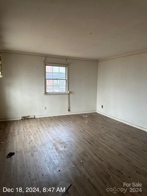 unfurnished room featuring dark hardwood / wood-style floors and crown molding