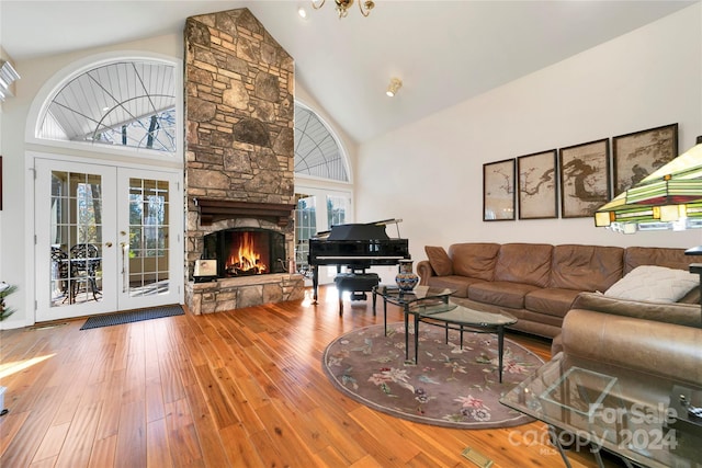 living room with hardwood / wood-style floors, high vaulted ceiling, a healthy amount of sunlight, and french doors