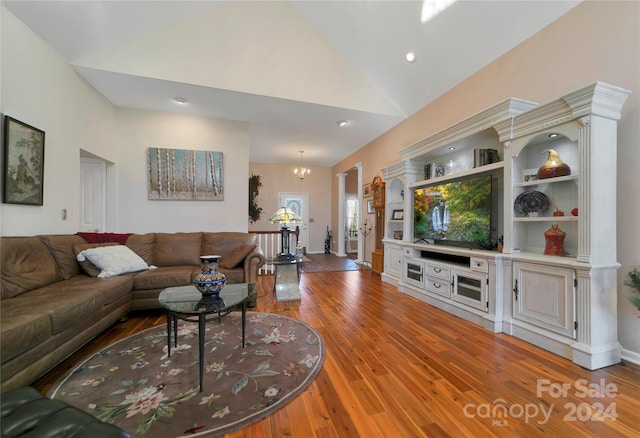 living room featuring light wood-type flooring, high vaulted ceiling, and a chandelier