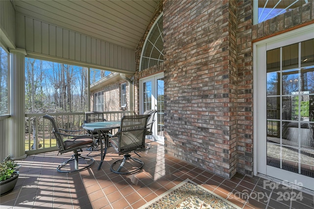 unfurnished sunroom featuring a wealth of natural light and lofted ceiling