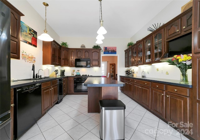 kitchen with dark brown cabinetry, a kitchen island, black appliances, and decorative light fixtures