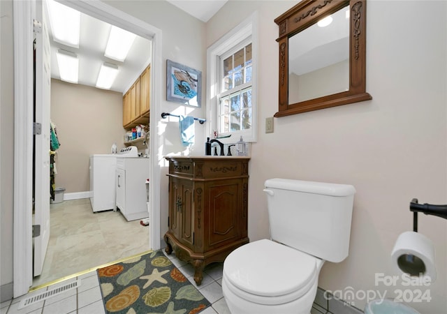 bathroom featuring tile patterned flooring, separate washer and dryer, toilet, and sink