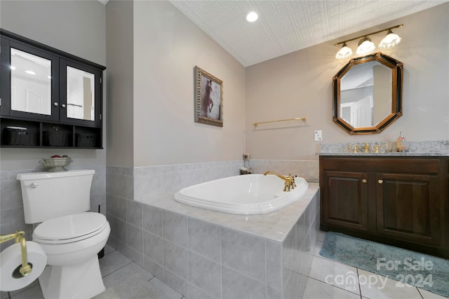 bathroom with toilet, vanity, a relaxing tiled tub, and tile patterned floors