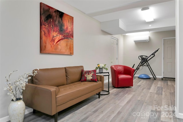 living room with light hardwood / wood-style flooring and a wall mounted air conditioner