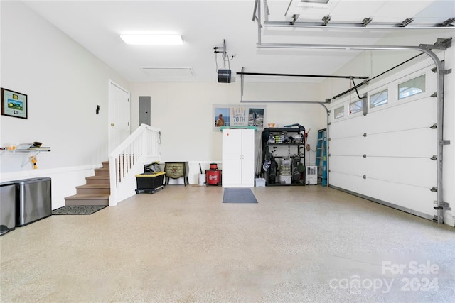 garage with electric panel and a garage door opener