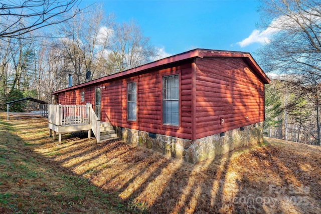 view of side of home with a deck and a carport