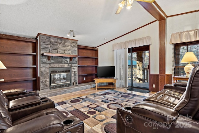 living room featuring lofted ceiling, a stone fireplace, ceiling fan, built in features, and a textured ceiling