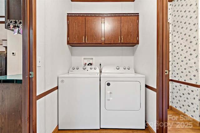 laundry area with light hardwood / wood-style floors, cabinets, and independent washer and dryer