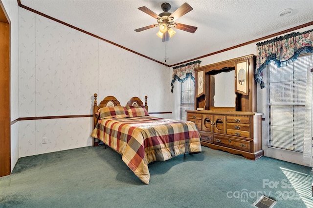 carpeted bedroom featuring ceiling fan, crown molding, and a textured ceiling