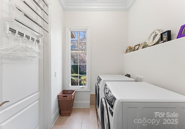 laundry area with light tile patterned floors, washer and clothes dryer, and ornamental molding