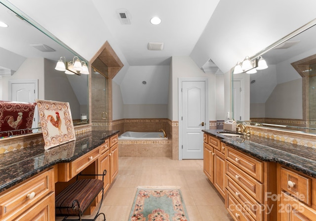 bathroom featuring independent shower and bath, vaulted ceiling, tile patterned floors, and vanity