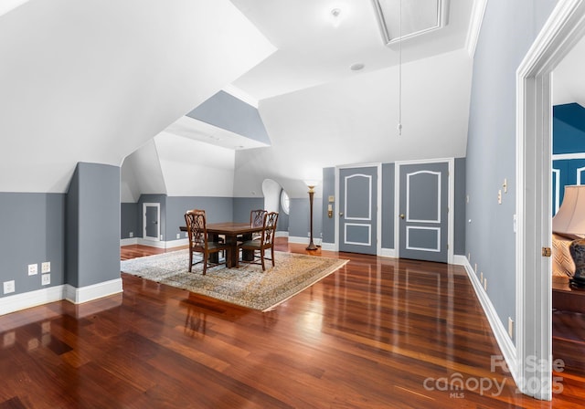 dining space featuring dark hardwood / wood-style flooring and vaulted ceiling