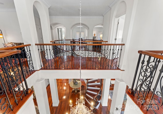 stairway featuring an inviting chandelier and crown molding