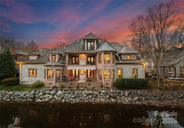 back house at dusk with a balcony