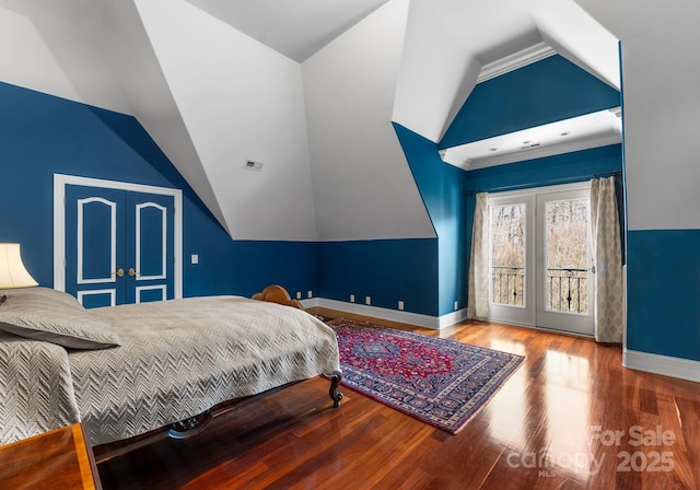 bedroom featuring hardwood / wood-style flooring, vaulted ceiling, and access to outside