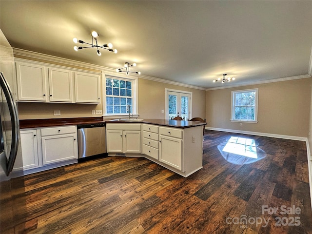 kitchen with kitchen peninsula, stainless steel appliances, white cabinets, and sink