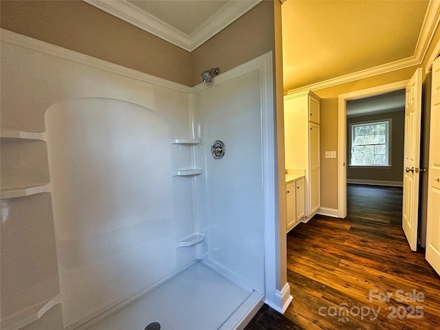 bathroom featuring walk in shower, crown molding, vanity, and hardwood / wood-style flooring