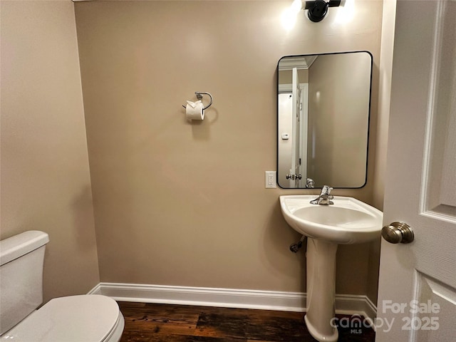 bathroom with hardwood / wood-style flooring and toilet