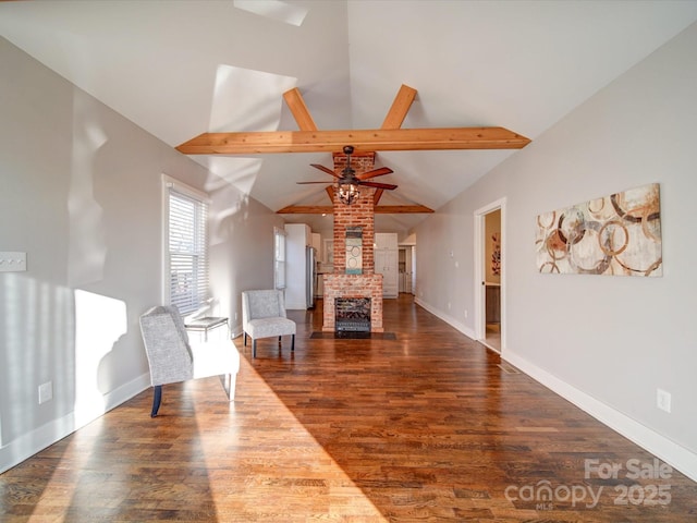 living room featuring vaulted ceiling with beams, dark hardwood / wood-style floors, a fireplace, and ceiling fan