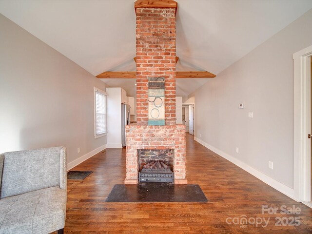 living room featuring a fireplace, dark hardwood / wood-style flooring, and vaulted ceiling with beams