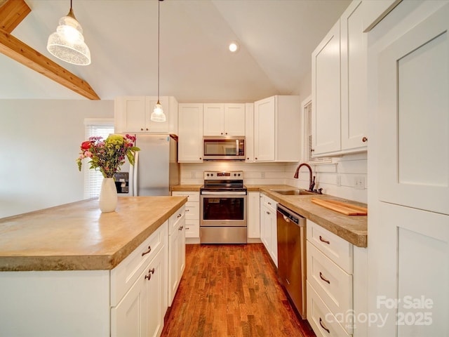 kitchen with pendant lighting, sink, white cabinets, and stainless steel appliances